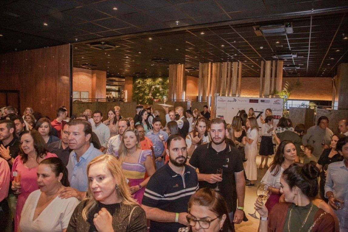 Um grande grupo de pessoas está em pé em uma sala.