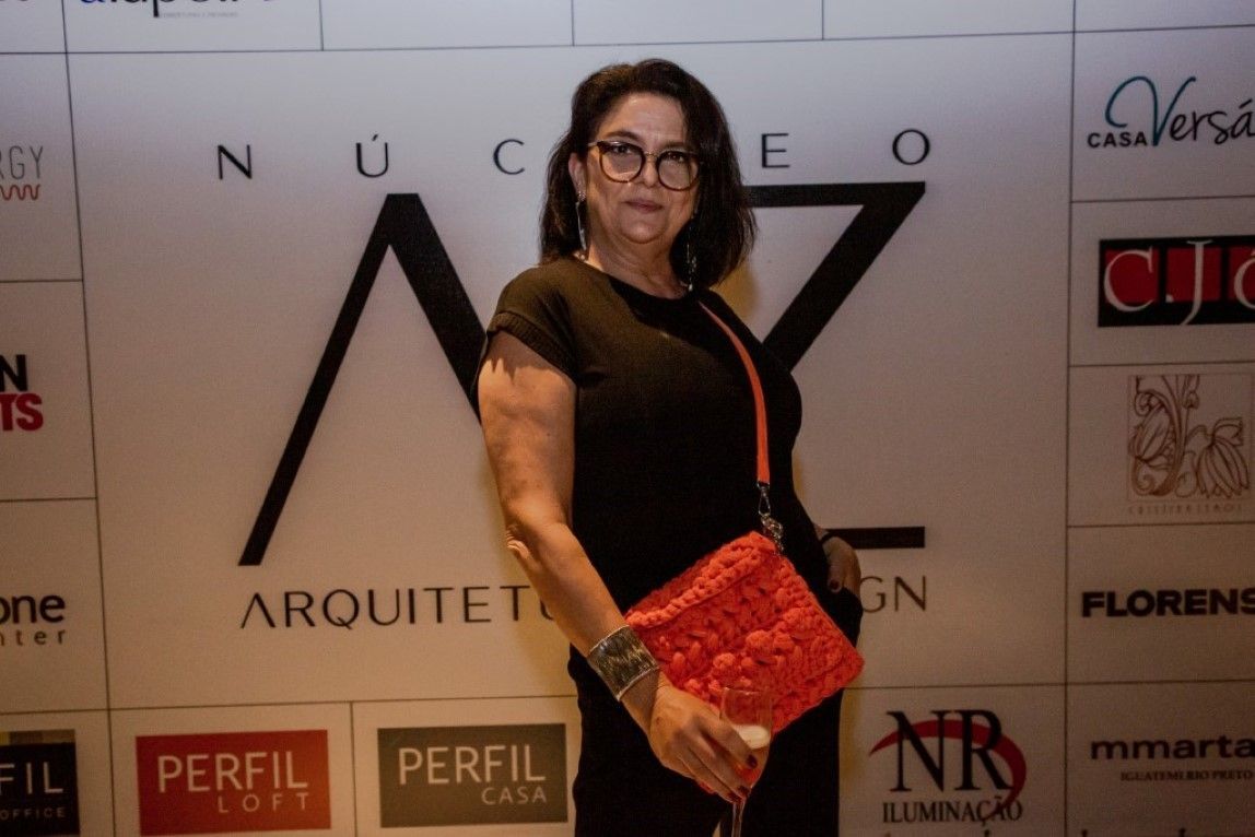 Uma mulher está parada em frente a uma parede que diz perfil