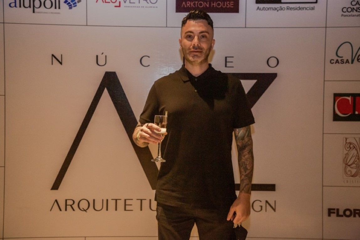 Um homem parado em frente a uma parede que diz arquiteto