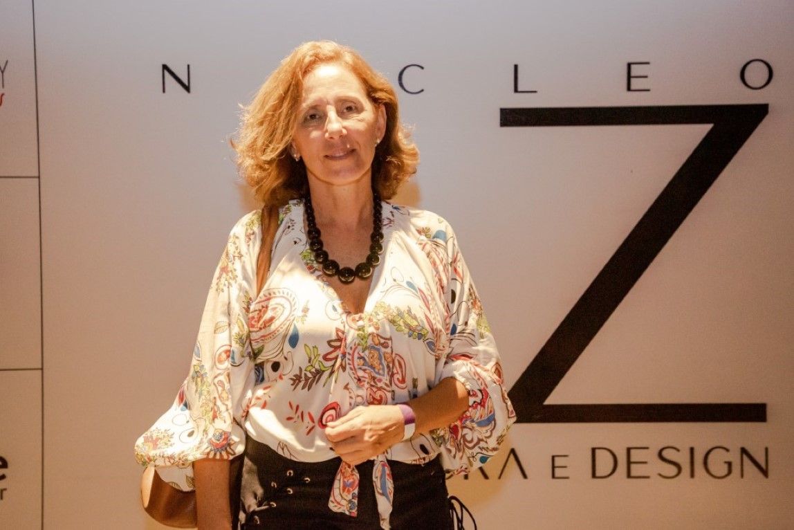 Uma mulher está parada em frente a uma parede com a letra z nela