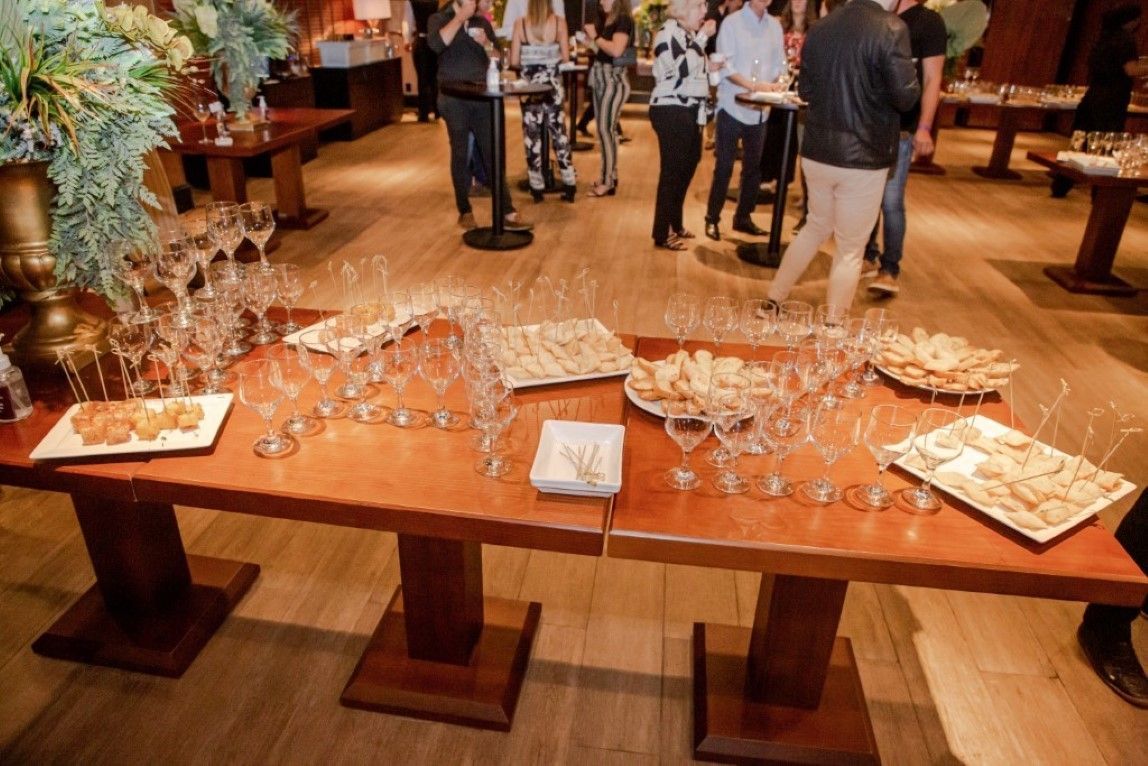 Uma mesa de madeira com pratos de comida e taças de vinho sobre ela.