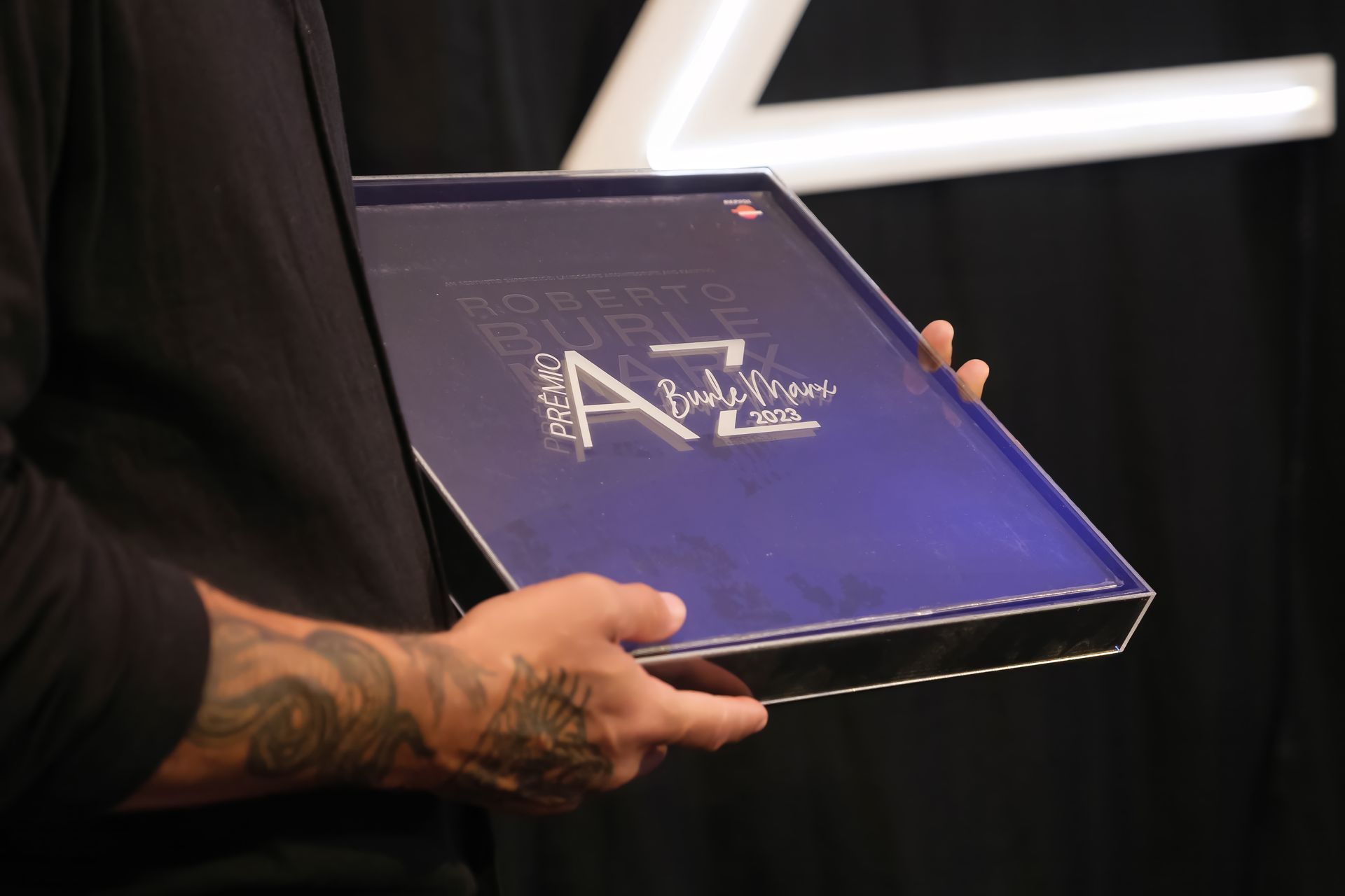 Um homem está segurando uma caixa azul com a letra az nela