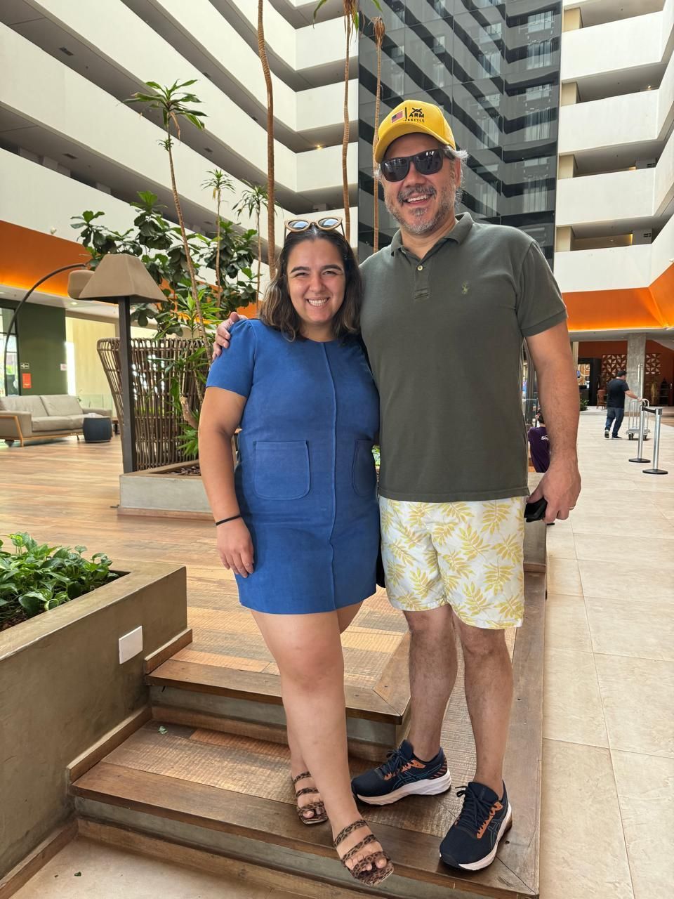 Um homem e uma mulher estão posando para uma foto em frente a um prédio.