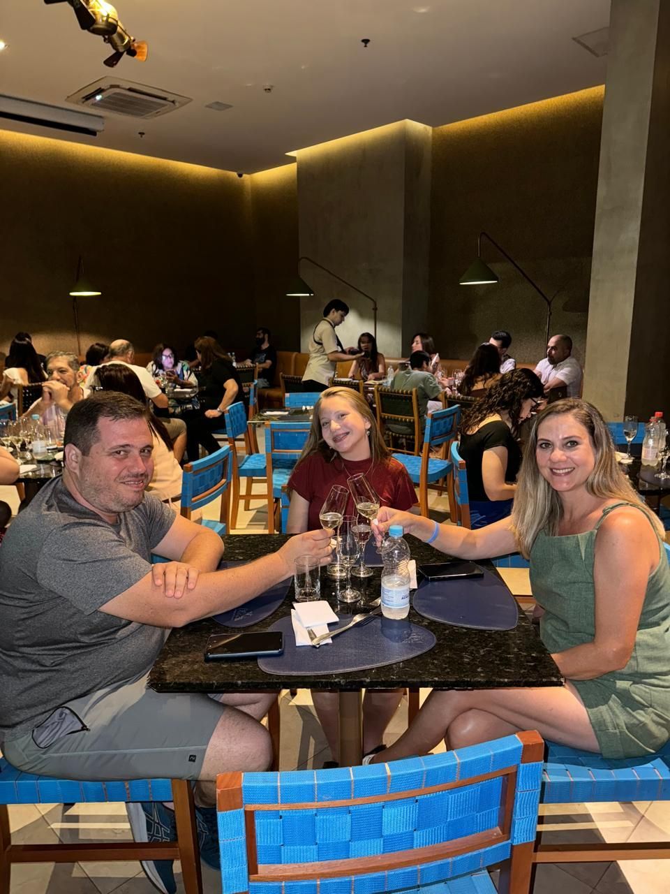 Um grupo de pessoas está sentado em mesas em um restaurante.