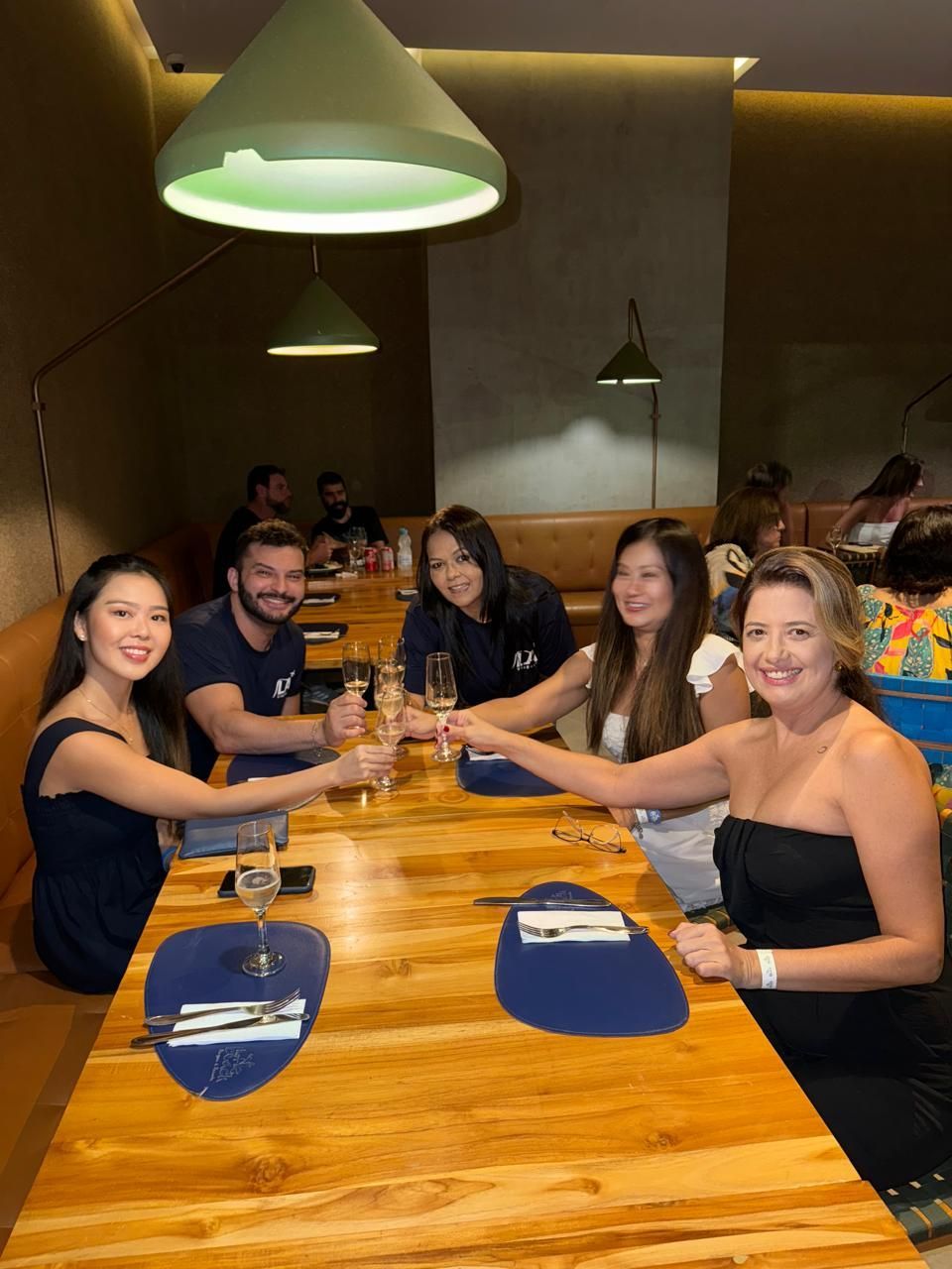 Um grupo de pessoas está sentado à mesa em um restaurante.