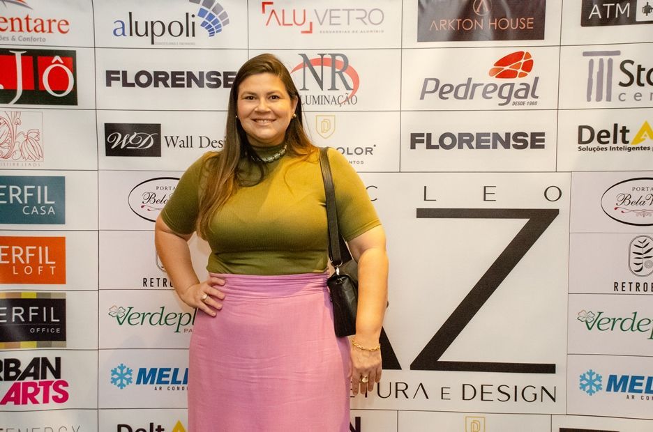 Uma mulher está parada em frente a uma parede com logotipos.