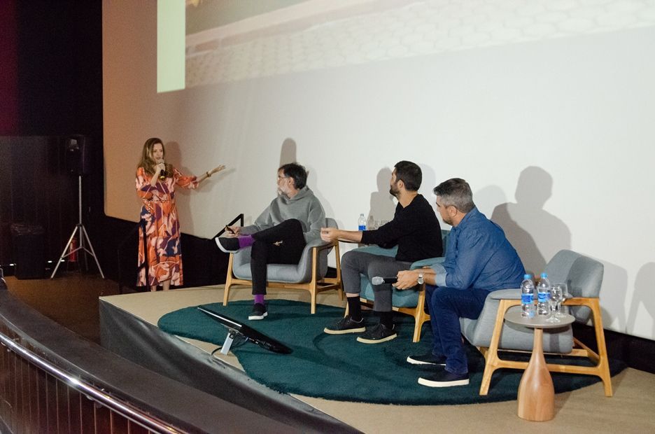 Uma mulher está fazendo uma apresentação para um grupo de pessoas sentadas em cadeiras.