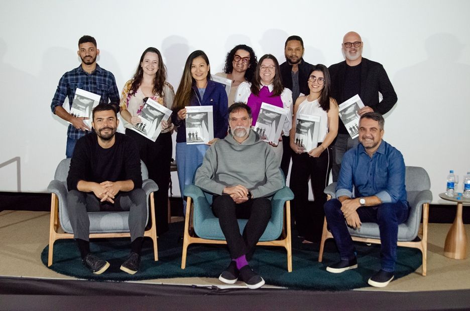 Um grupo de pessoas está posando para uma foto sentadas em cadeiras.