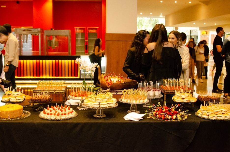 Um grupo de pessoas está em volta de uma mesa com muita comida.