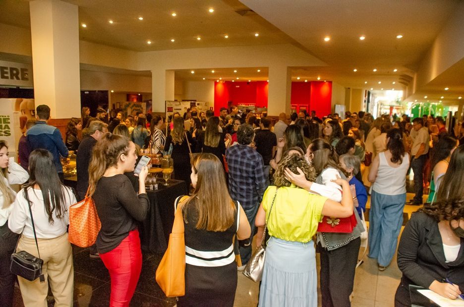 Um grande grupo de pessoas está em pé em uma sala.