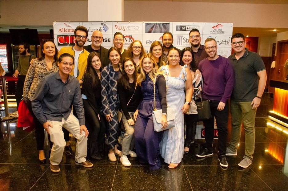 Um grupo de pessoas está posando para uma foto em uma sala.