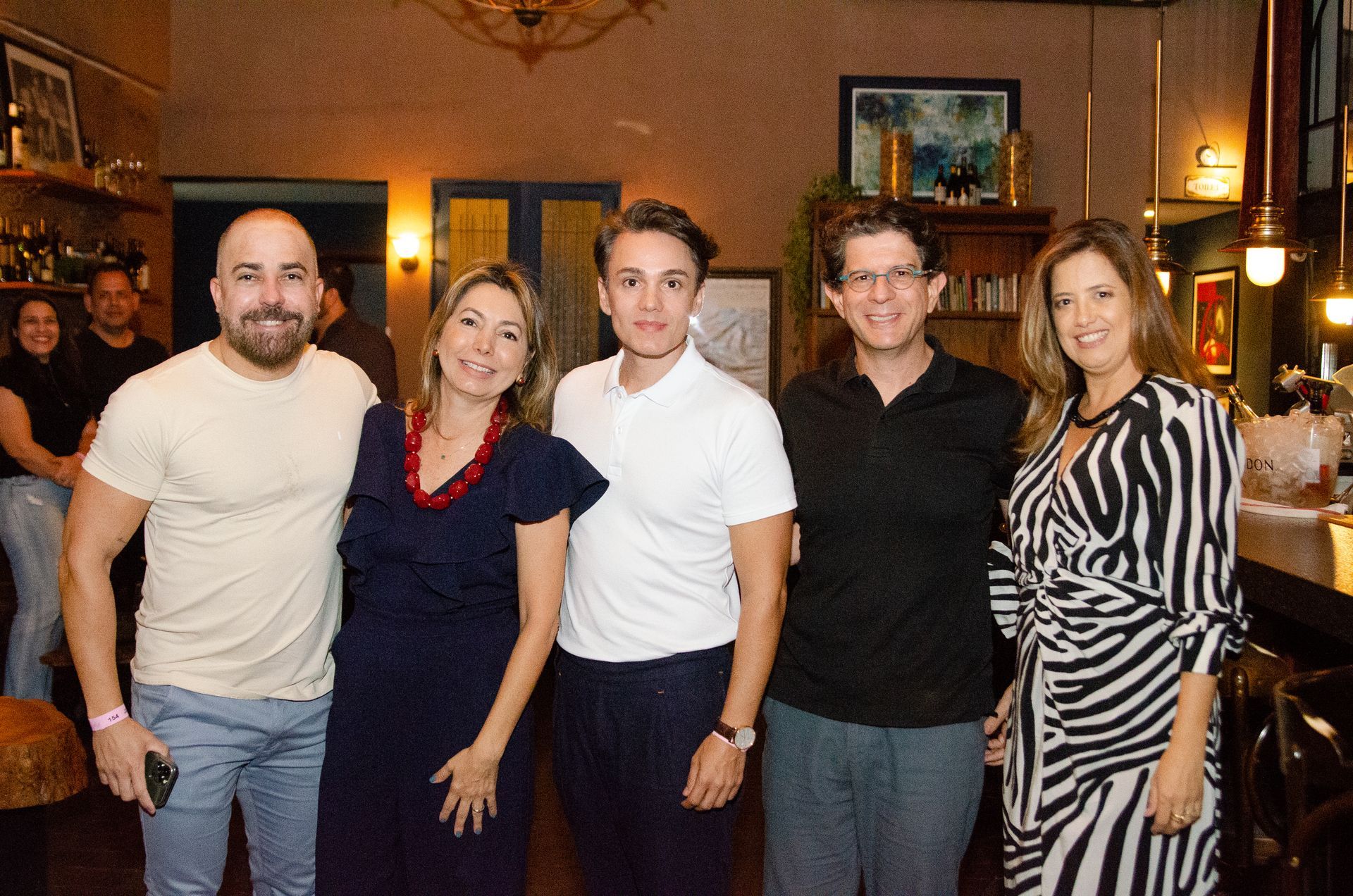 Um grupo de pessoas está posando para uma foto em uma sala.