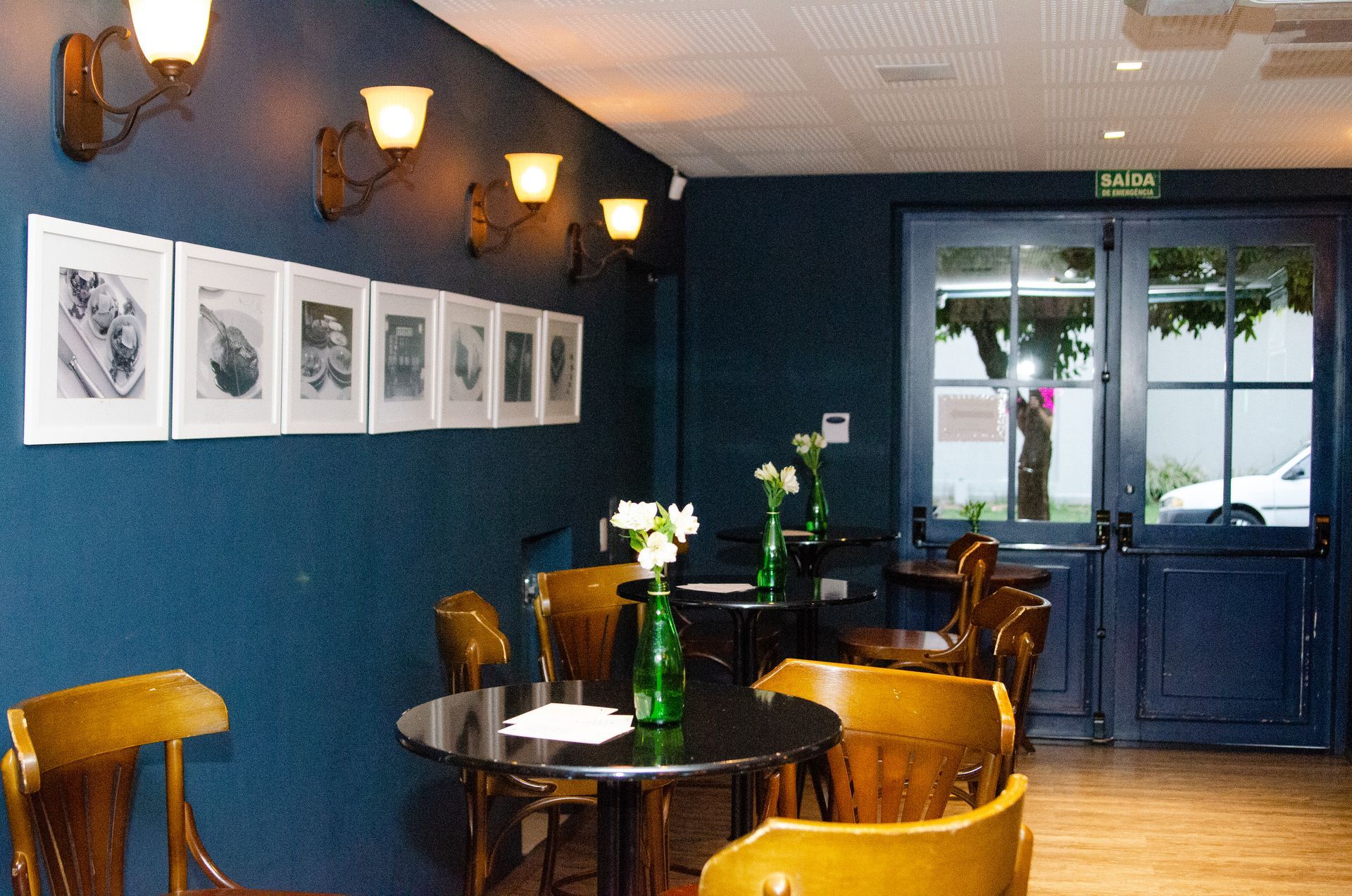 Uma sala com mesas e cadeiras e uma placa que diz saída