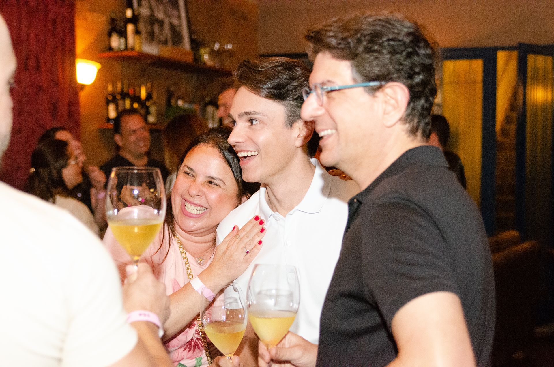 Um grupo de pessoas está segurando taças de vinho e sorrindo.