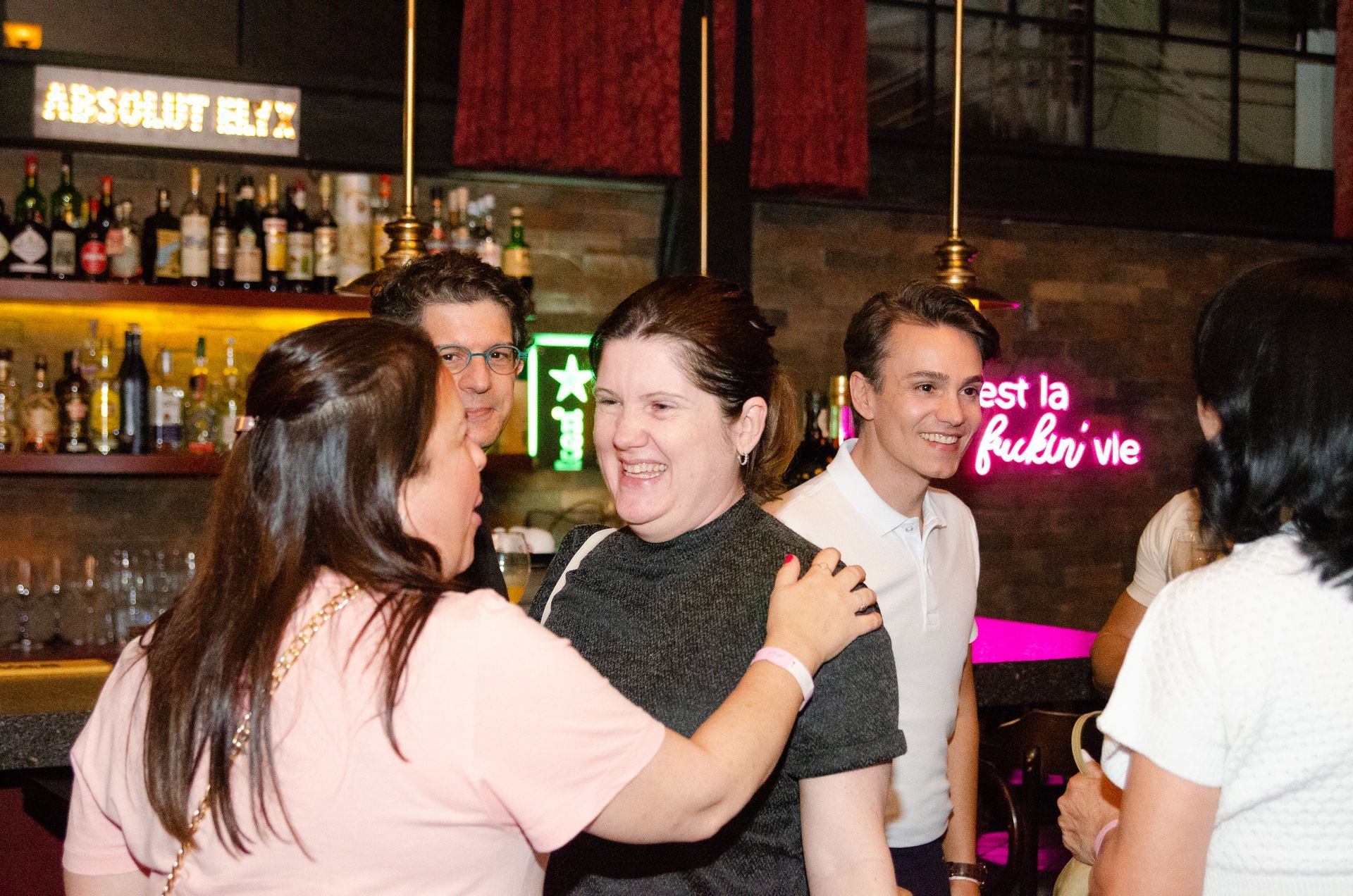 Um grupo de pessoas está se abraçando em um bar.