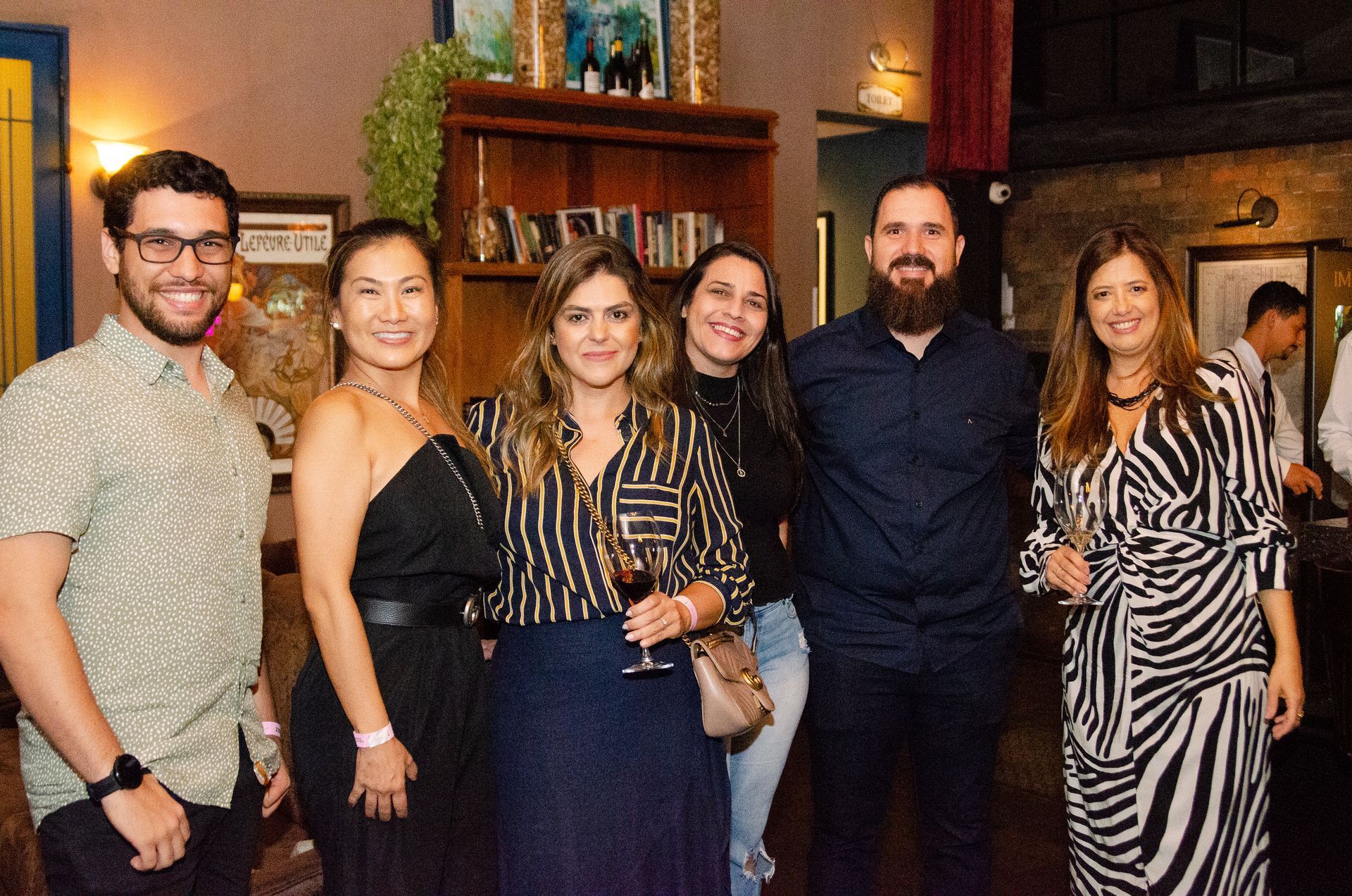 Um grupo de pessoas está posando para uma foto em uma sala.