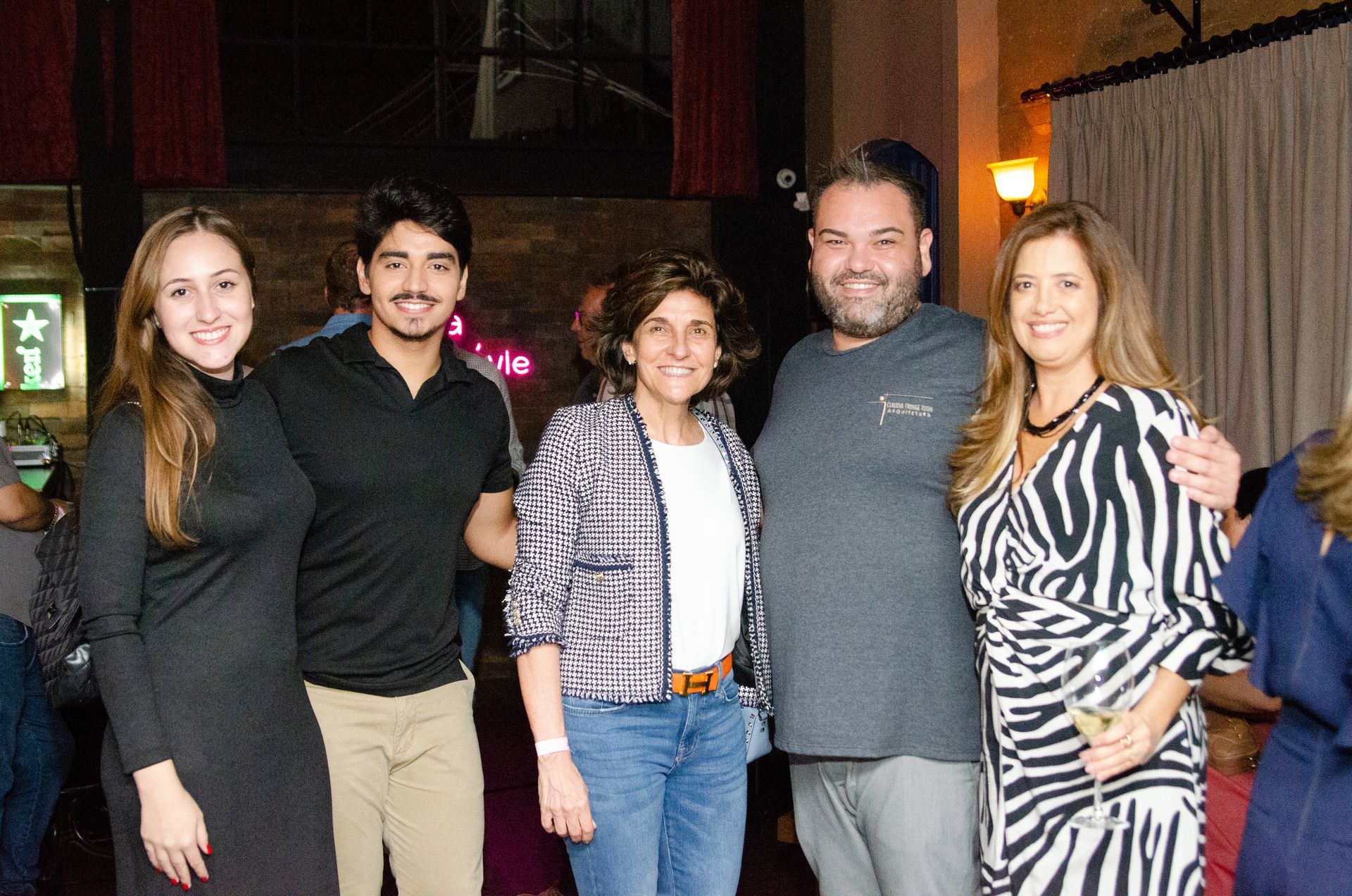 Um grupo de pessoas está posando para uma foto juntas em uma sala.