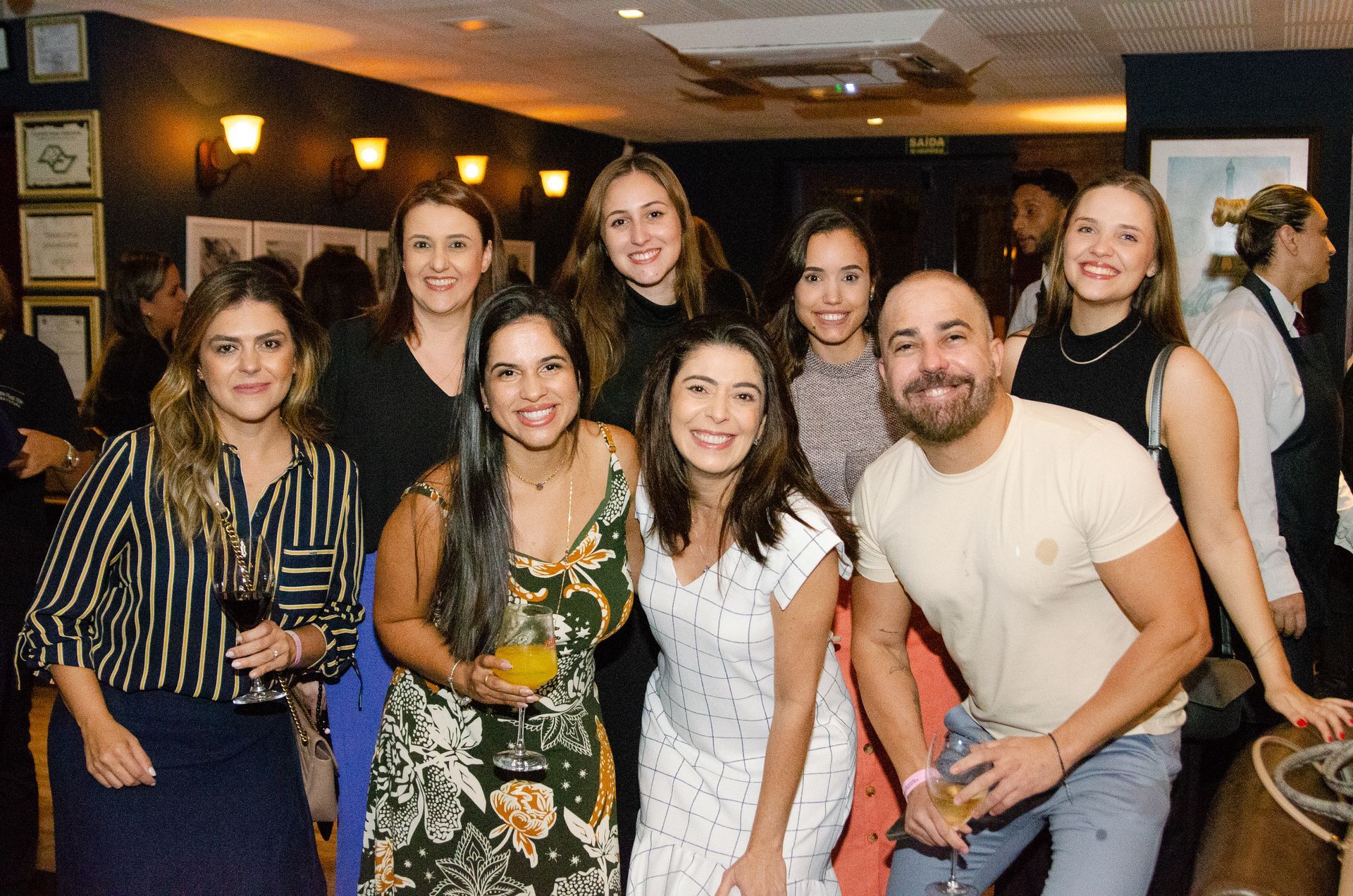 Um grupo de pessoas está posando para uma foto em uma sala.