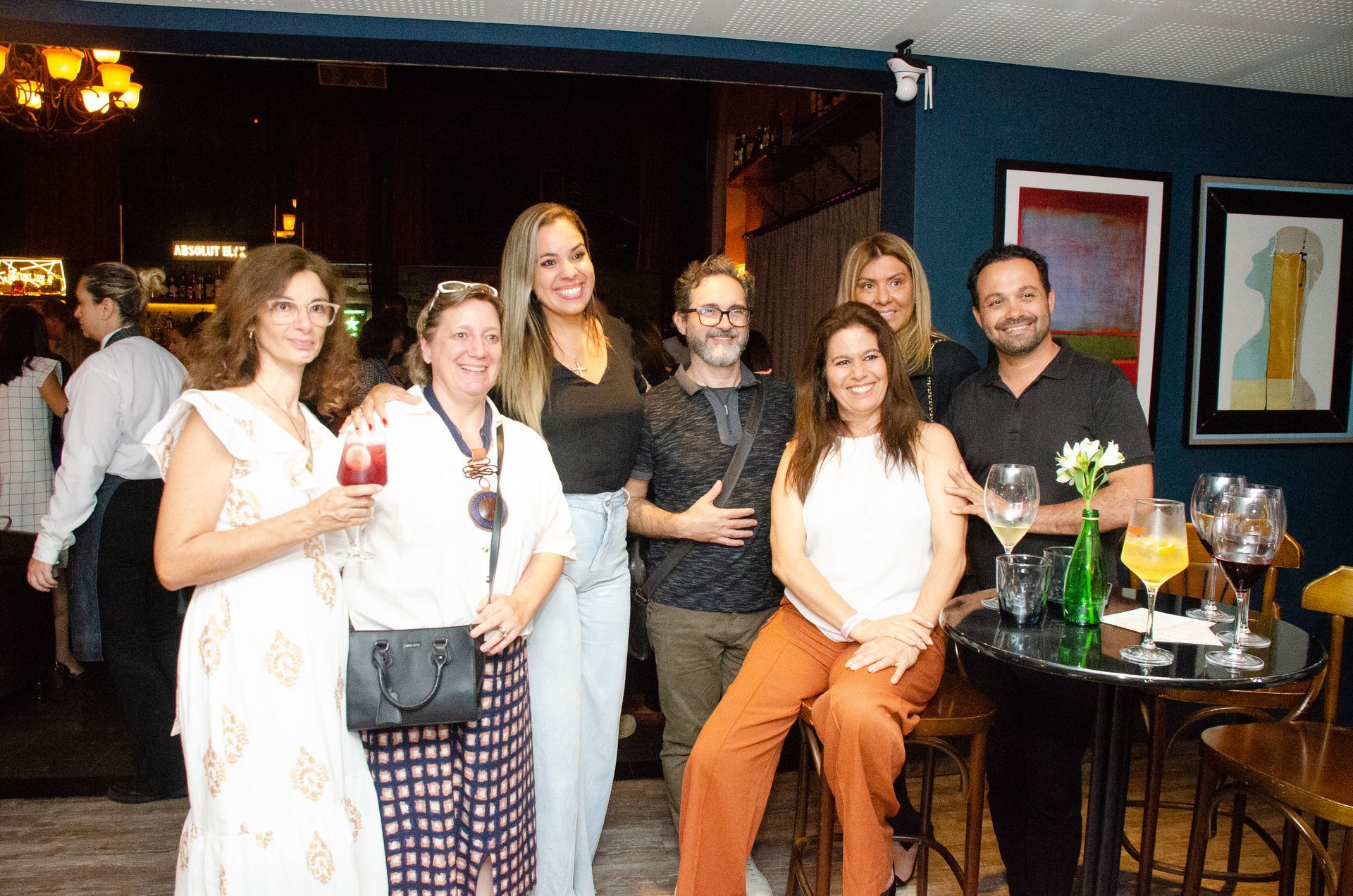 Um grupo de pessoas está posando para uma foto em um restaurante.