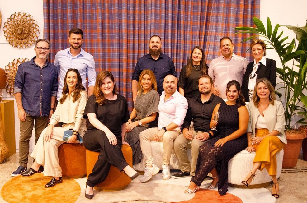 Um grupo de pessoas está posando para uma foto em uma sala.