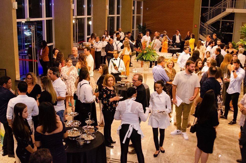 Um grande grupo de pessoas está em pé em uma sala.