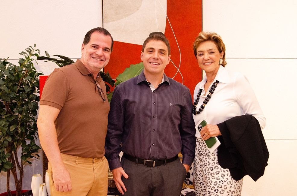 Dois homens e uma mulher estão posando para uma foto juntos