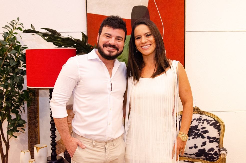 Um homem e uma mulher estão posando para uma foto em uma sala de estar.