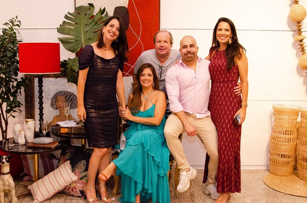 Um grupo de pessoas está posando para uma foto juntas em uma sala.