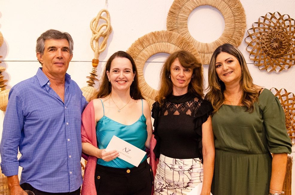 Um grupo de pessoas está posando para uma foto em frente a uma parede.