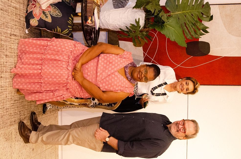 Um grupo de pessoas está posando para uma foto em uma sala de estar.