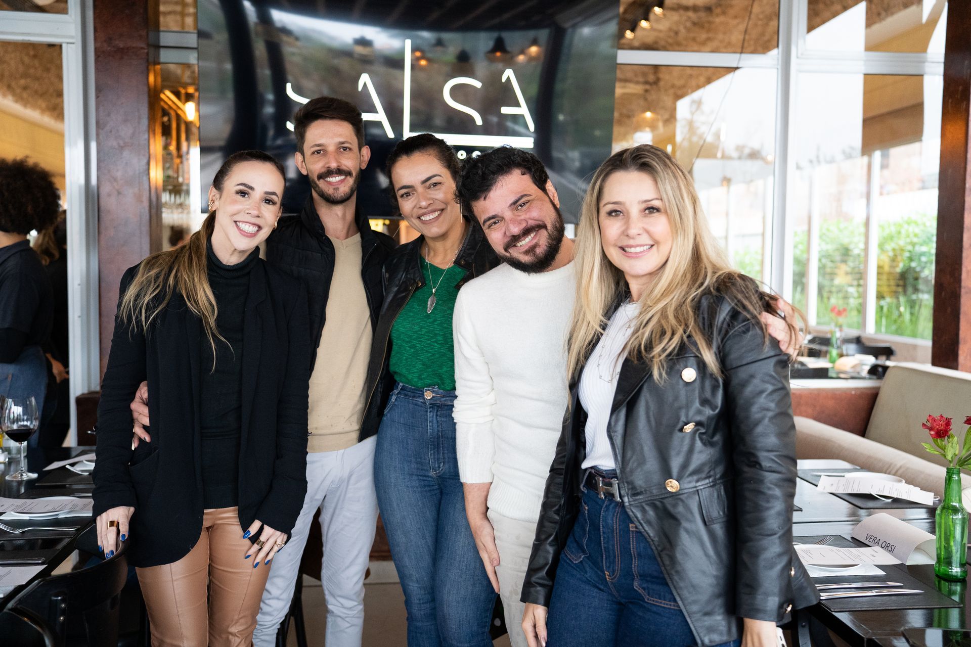 Um grupo de pessoas está posando para uma foto em um restaurante.