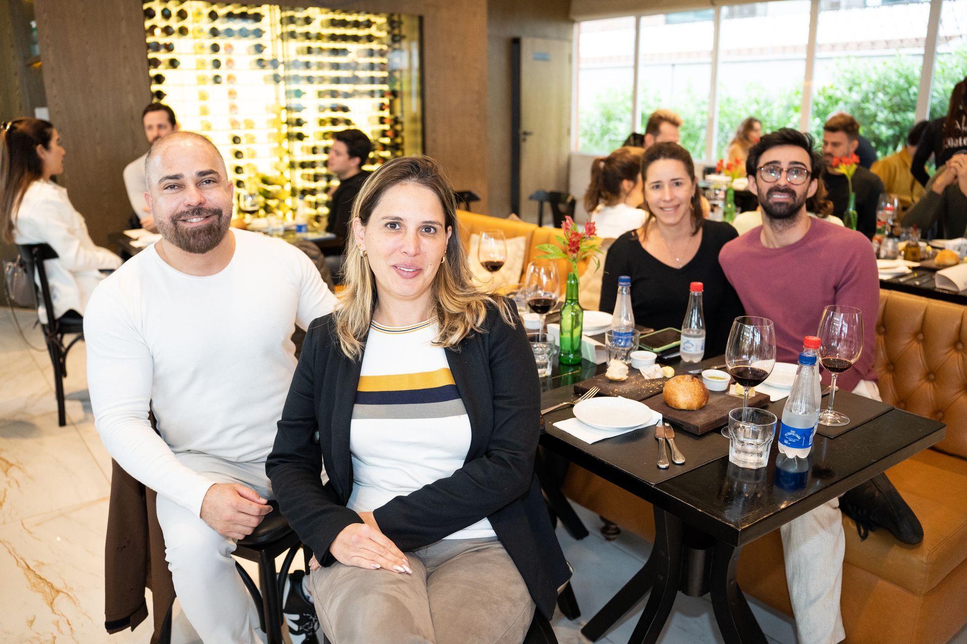 Um grupo de pessoas está sentado em mesas em um restaurante.