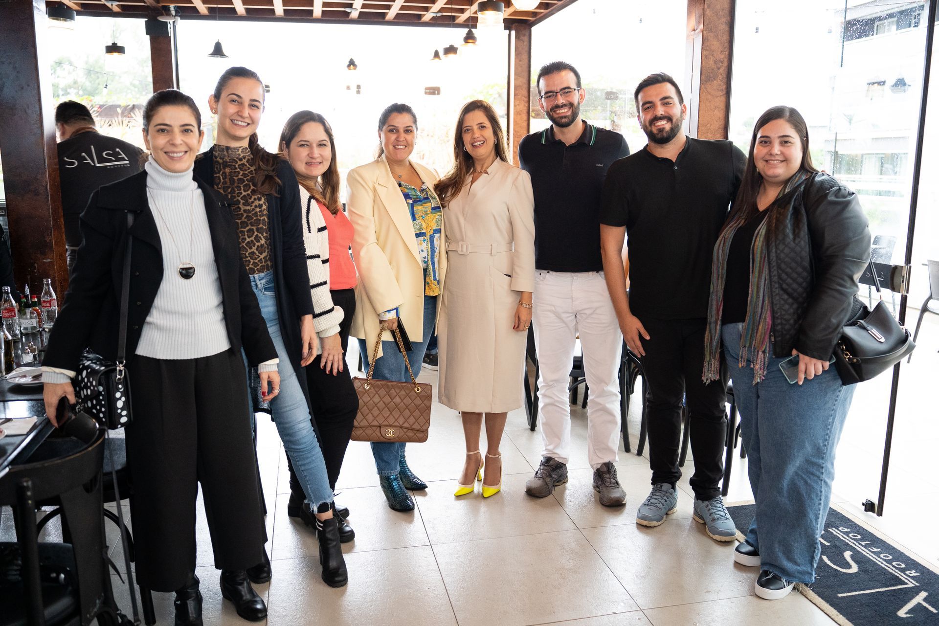 Um grupo de pessoas está posando para uma foto juntas em uma sala.