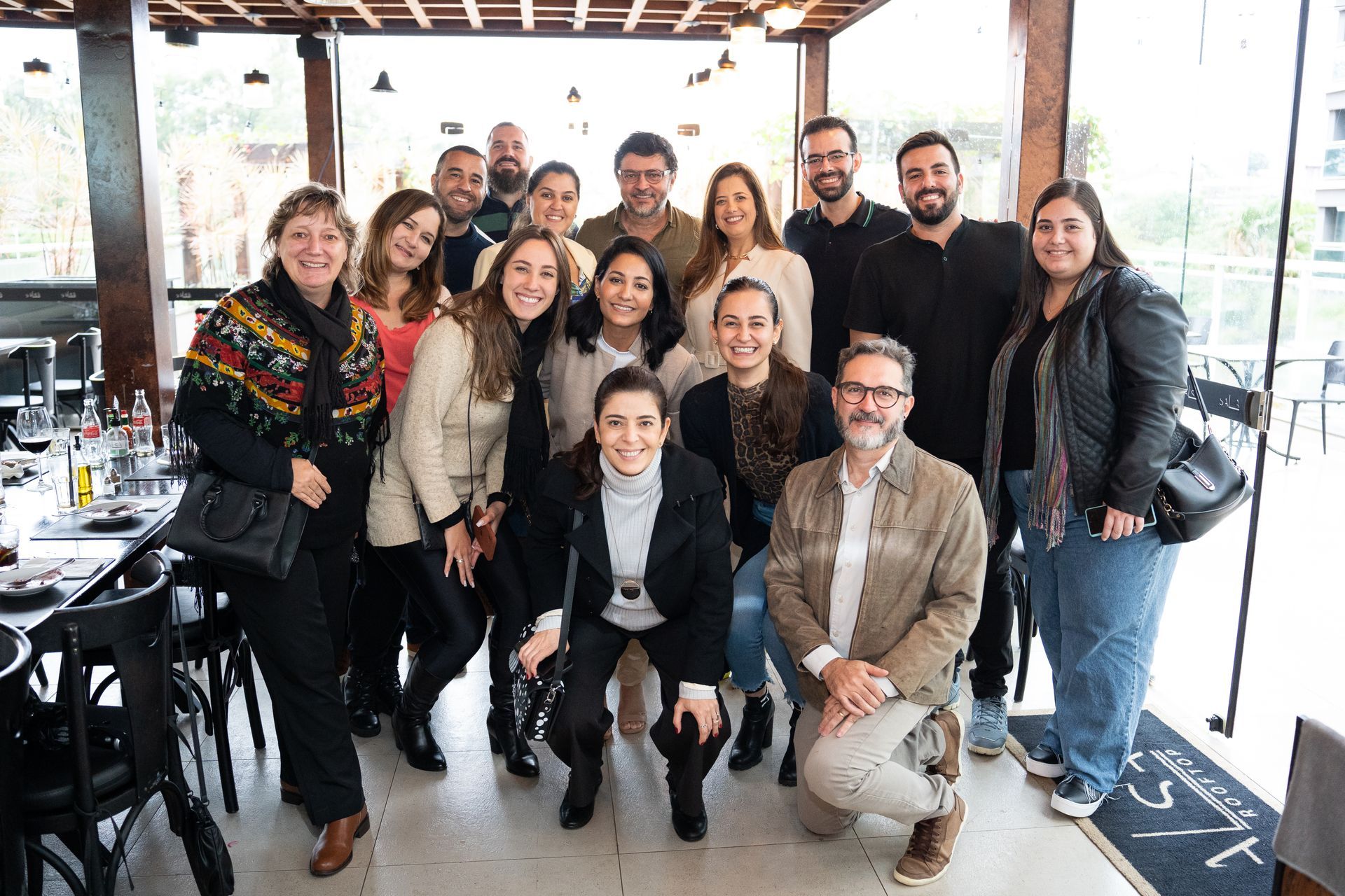 Um grupo de pessoas está posando para uma foto em um restaurante.