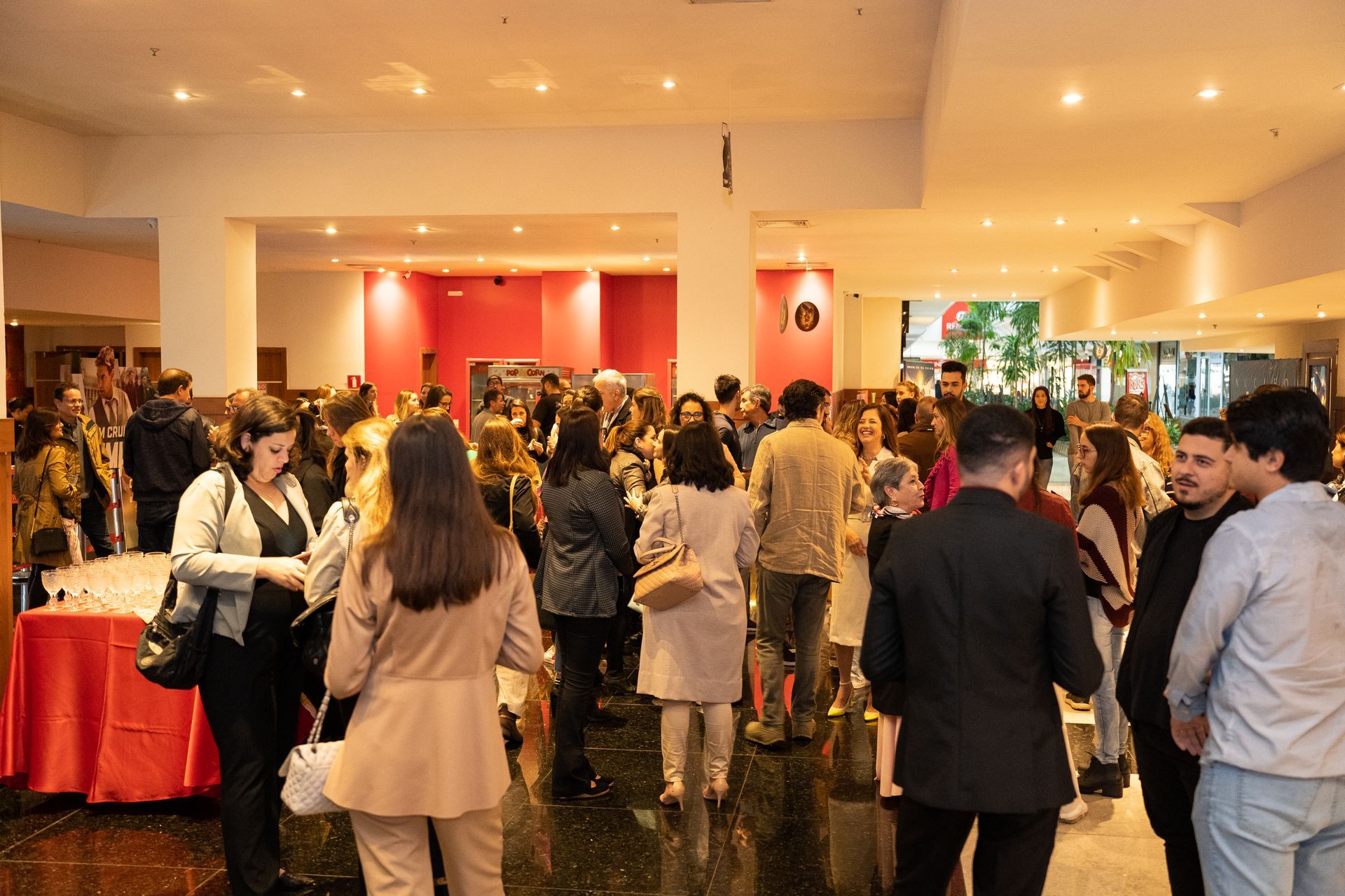 Um grande grupo de pessoas está em pé em uma sala.