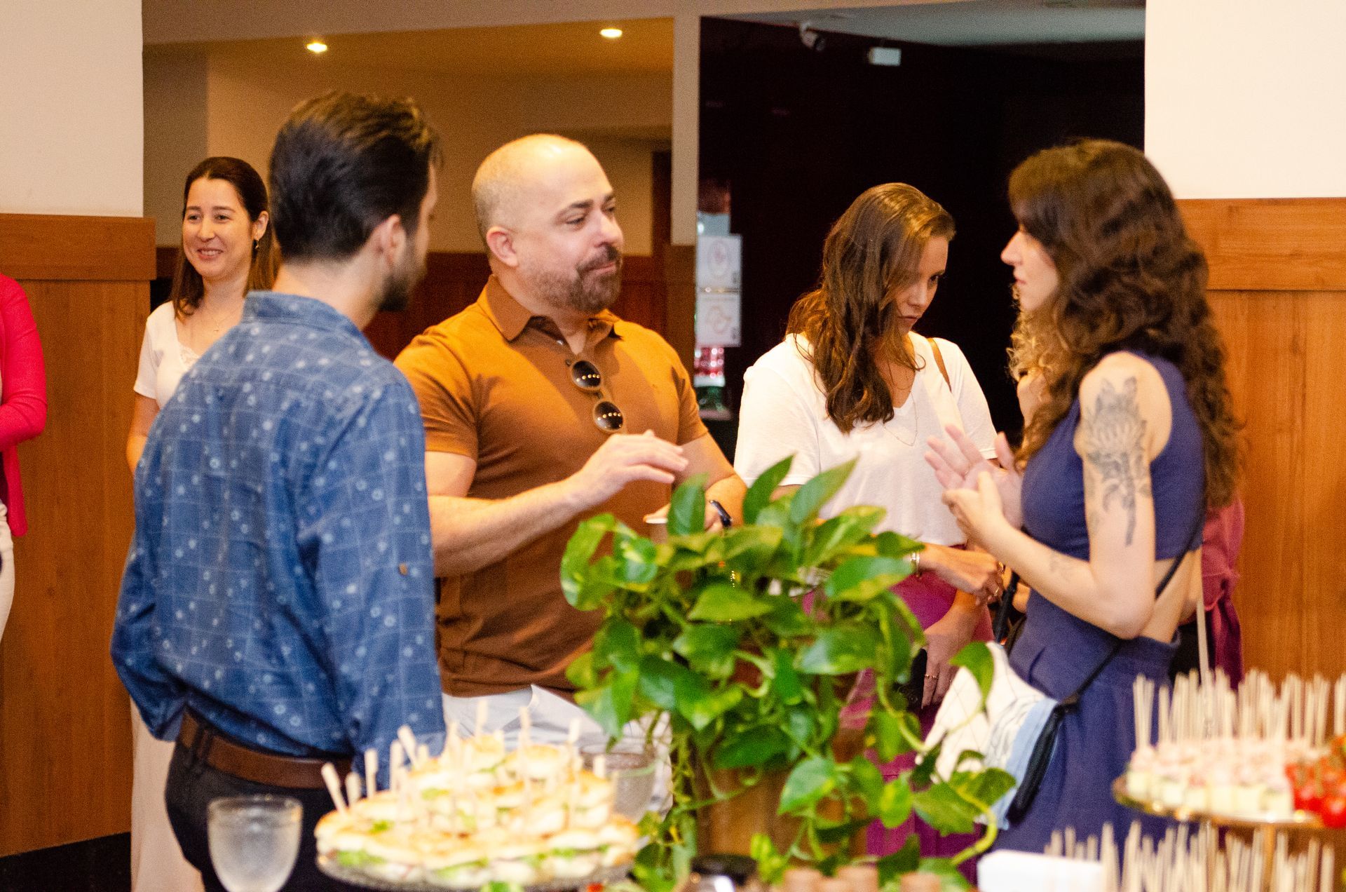 Um grupo de pessoas está em volta de uma mesa conversando entre si.