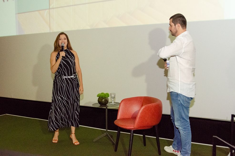 Um homem está de pé ao lado de uma mulher segurando um microfone.