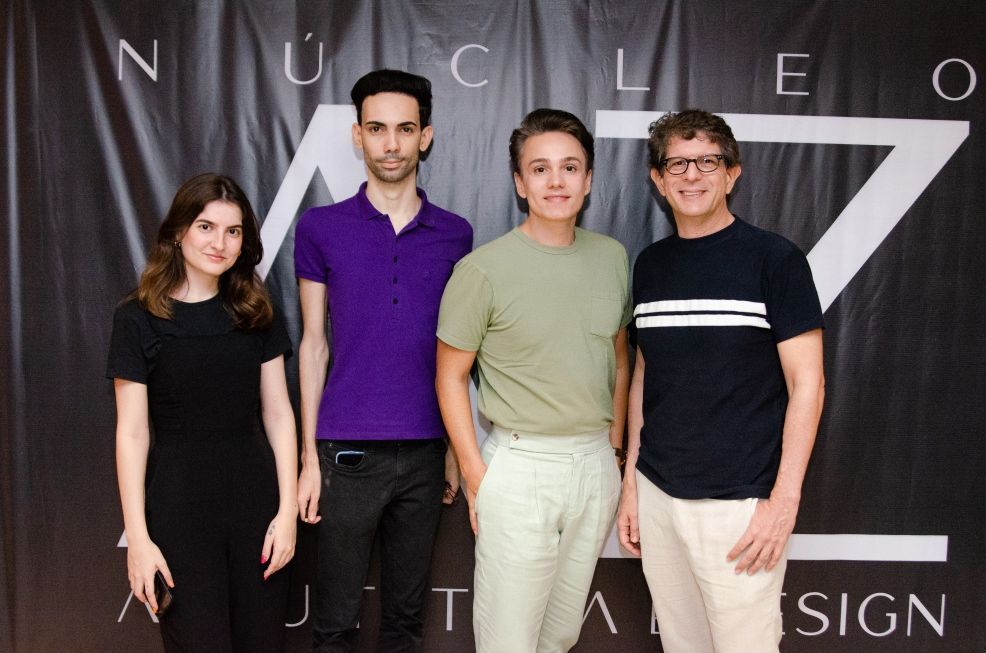 Um grupo de pessoas posando para uma foto em frente a uma placa que diz nucleo