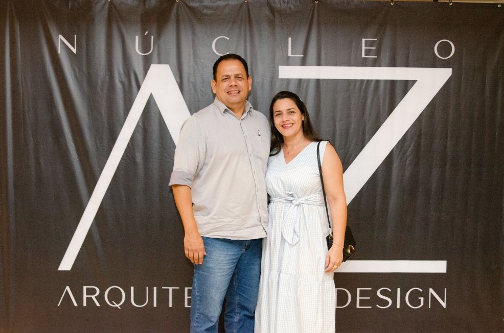 Um homem e uma mulher em pé na frente de uma placa que diz arquitet design