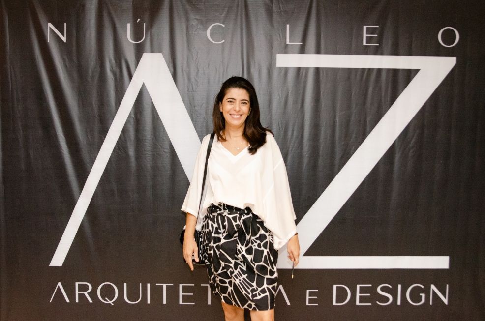 Uma mulher está em frente a uma placa que diz arquiteta e design