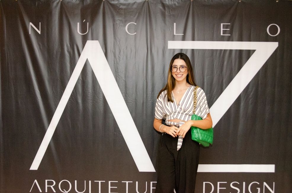 Uma mulher parada em frente a uma placa que diz arquitetue design