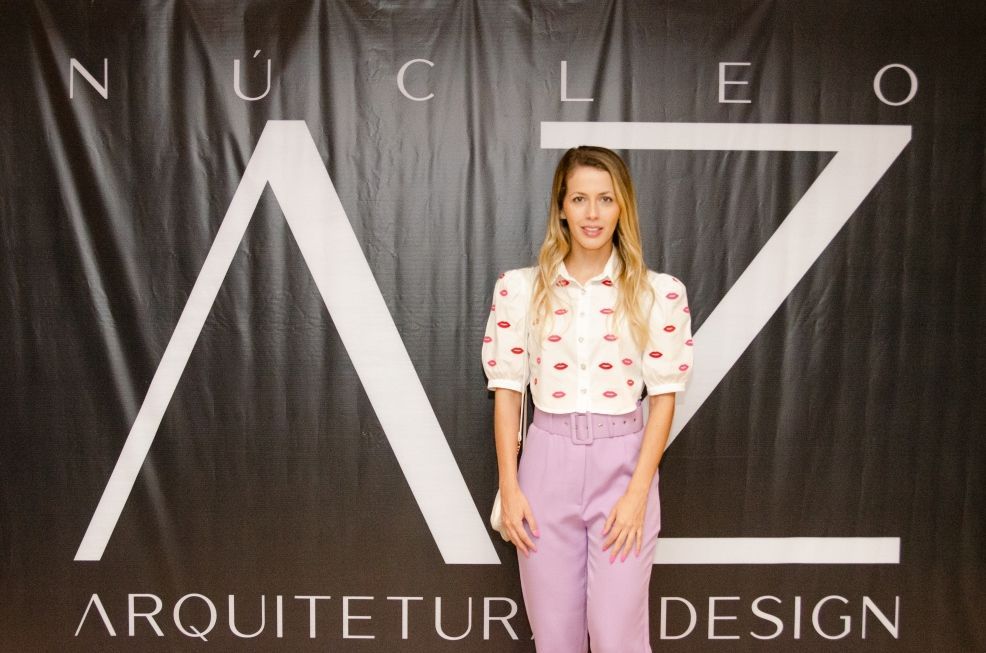 Uma mulher está parada em frente a uma placa que diz arquitet design