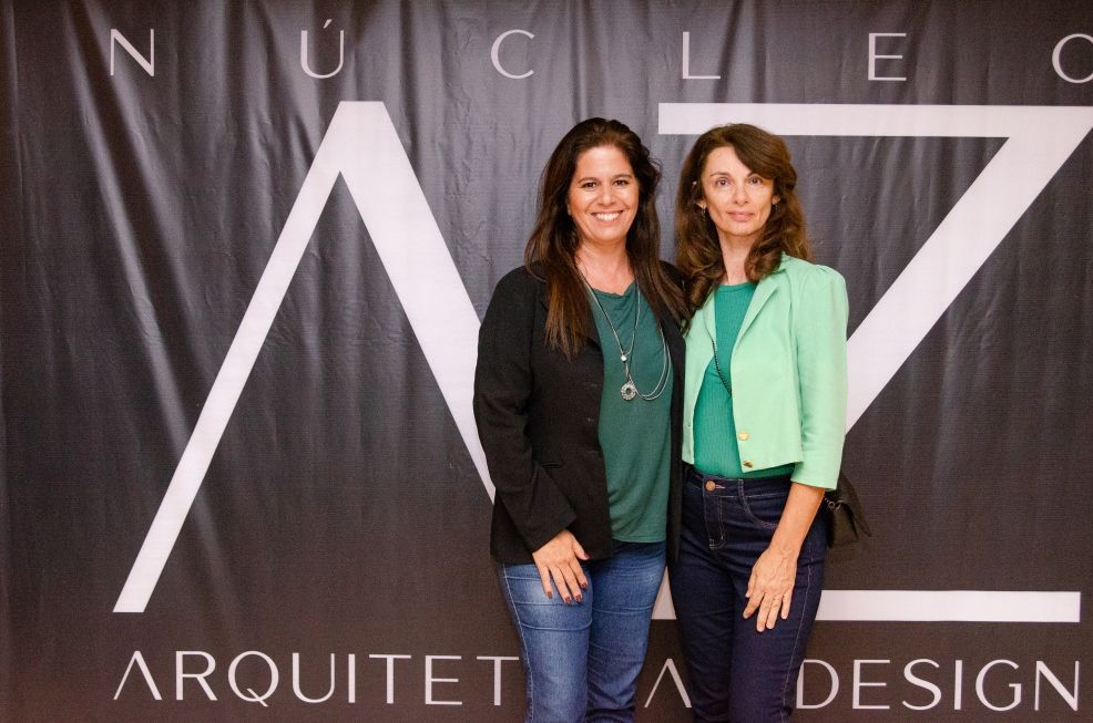Duas mulheres em pé na frente de uma placa que diz arquiteta design