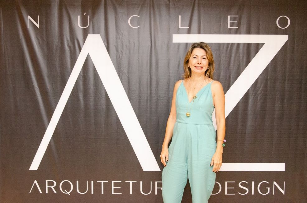 Uma mulher parada em frente a uma placa que diz arquitet design