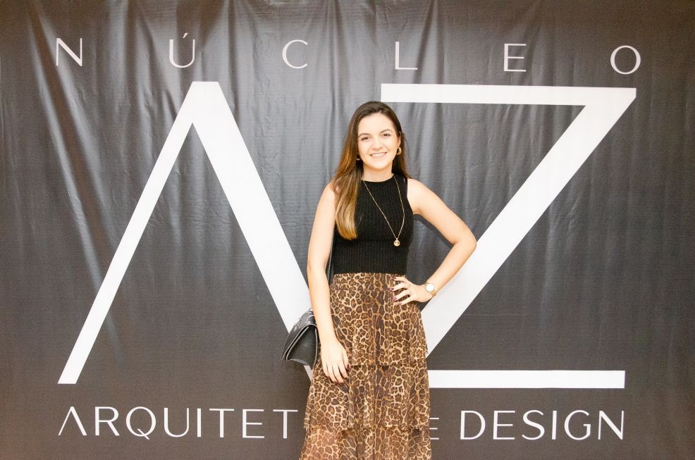 Uma mulher está em frente a uma placa que diz arquitete design