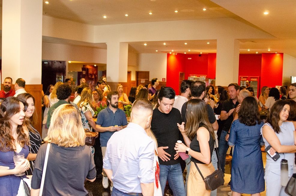 Um grande grupo de pessoas está em pé em uma sala.