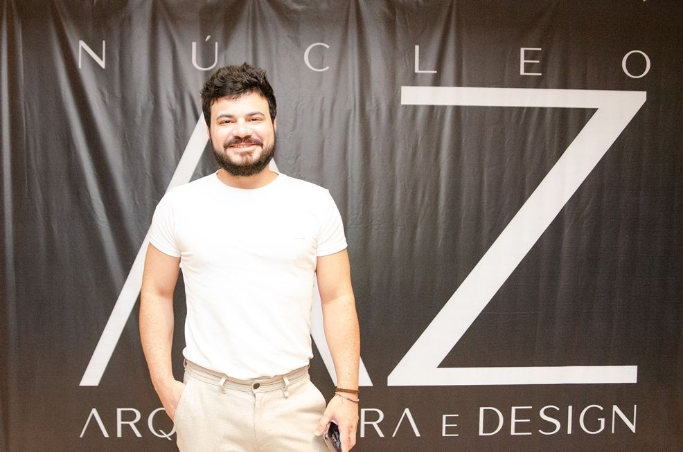 Um homem parado em frente a uma placa que diz nucleo