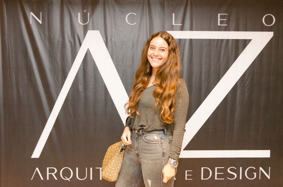 Uma mulher está em frente a uma placa que diz arquitete design