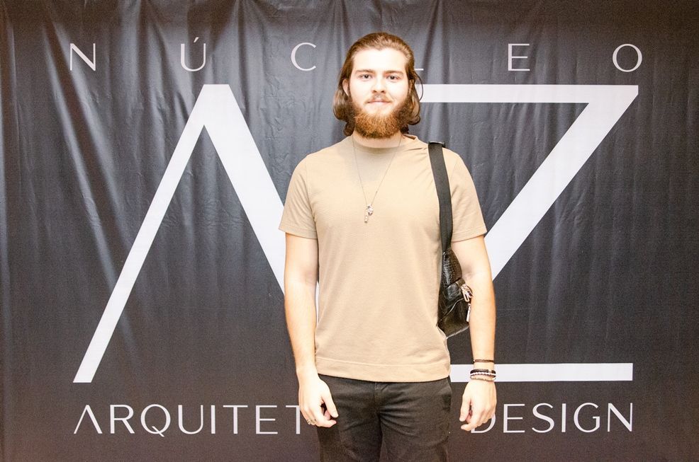 Um homem parado em frente a uma placa que diz arquiteto design