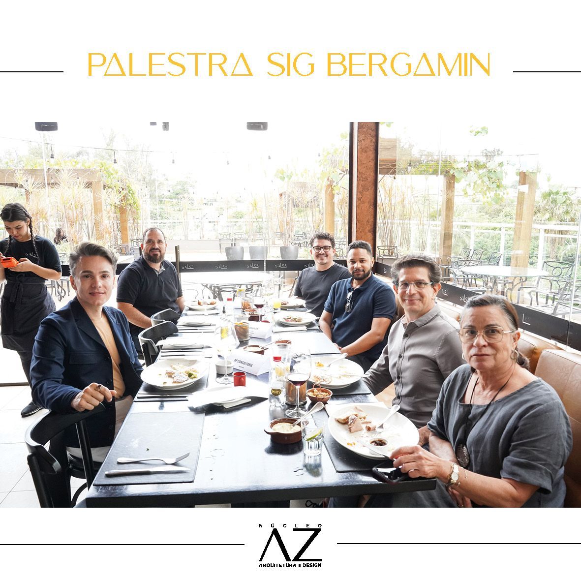 Um grupo de pessoas está sentado em uma mesa longa em um restaurante.